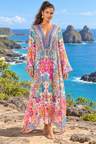 Eden Garden long caftan dress in pink and turquoise floral print with embellished V-neck, front view on Fernando de Noronha cliff - La Moda wholesale