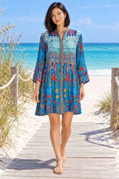 Turquoise blue boho print tunic mini dress with embroidered placket, front view on beach boardwalk - wholesale summer dress vendor
