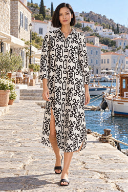 Women's off-white and black scroll ikat print button front midi shirt dress with side slits in a Greek island harbor - La Moda wholesale resort wear