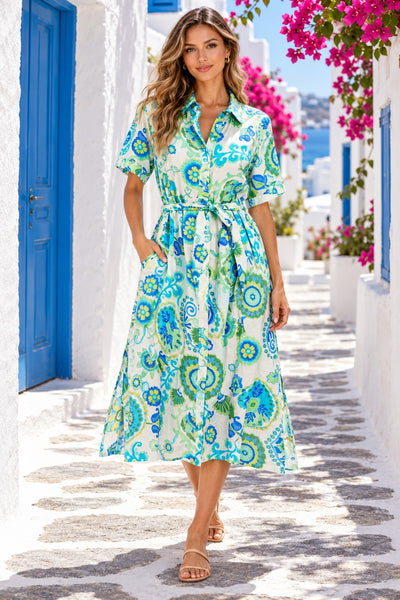 Blue green tropical medallion print belted midi shirt dress, front view on model in whitewashed Mykonos alley - La Moda Clothing wholesale resort wear