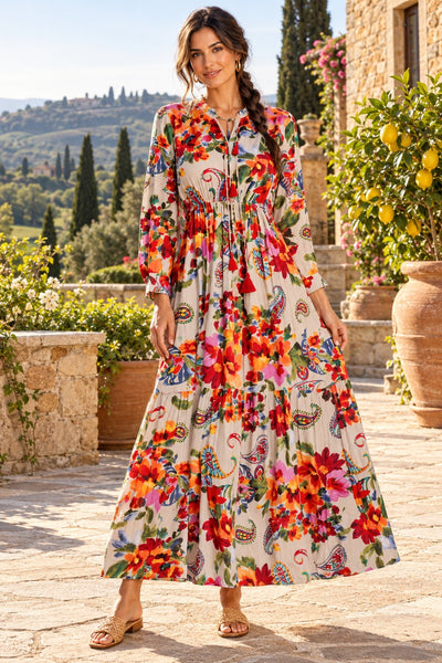 Women's taupe bohemian floral paisley long sleeve tiered maxi dress with tassel tie neckline in a Tuscan villa garden - La Moda wholesale boho dresses