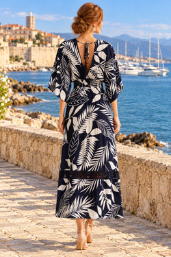Back view of navy tropical leaf print maxi dress with tie keyhole back overlooking a French Riviera harbor - La Moda vacation dress