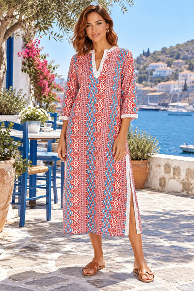 Women's red and teal ikat tile print lace trim tunic caftan midi dress on a Hydra taverna terrace - La Moda wholesale resort caftans