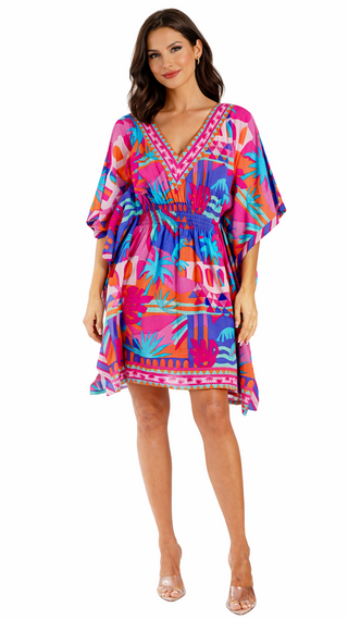 Woman wearing a colorful tropical print dress on a white background